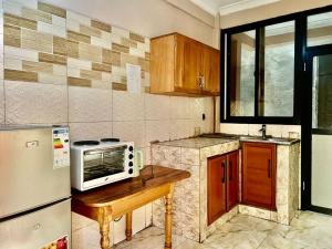 a kitchen with a microwave on a wooden table at DAVAROXE Appartements Lingwala RTNC in Kinshasa