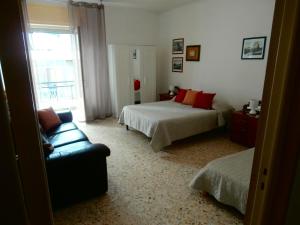 una camera da letto con due letti, una sedia e una finestra di La bella Putignano a Putignano