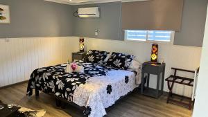 a bedroom with a bed with a black and white comforter at Inaki Uhi Hotel in Hanga Roa +71 photos