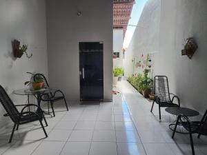 a hallway with tables and chairs and a table and chairs at Casa Serena - Quarto in Camocim
