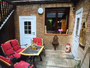 a patio with red chairs and a table and a door at Ferienwohnung Danielle Kessler in Idar-Oberstein