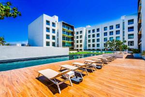 eine Reihe von Liegen und Stühlen neben einem Pool in der Unterkunft 3BR Cabo Condo Walk to Medano Beach & Marina in Cabo San Lucas