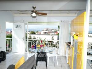 a living room with a table and a balcony at Appartement vue mer situé aux Trois-Ilets, Martinique in Les Trois-Îlets