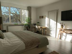 a bedroom with a bed and a desk and window at B&B Intilia in Kortrijk