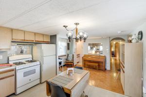a kitchen with white appliances and a dining room with a table at 2 Mi to Sturgis Motorcycle Rally Peaceful Home in Sturgis