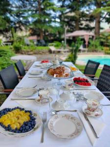una mesa larga con platos de comida y fruta. en Villa Laura, en Lierna