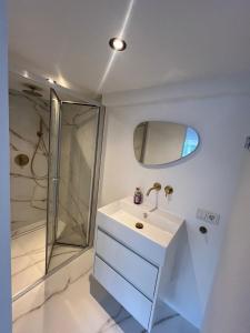 une salle de bain blanche avec un lavabo et une douche dans l'établissement WaalPlaat's B&B, à Amsterdam
