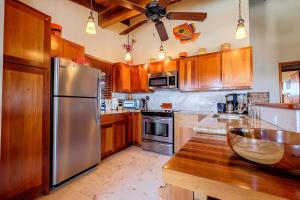 a kitchen with wooden cabinets and a stainless steel refrigerator at Indigo Belize 5C condo in San Pedro