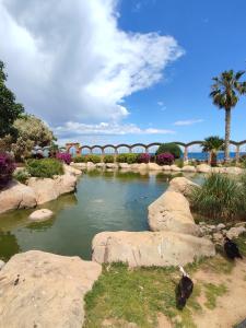 a river with rocks and a bridge in the background at Apartamento Maru's in Oropesa del Mar