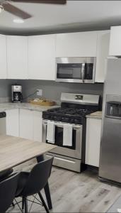 cocina con fogones y mesa. en The Oquirrh Retreat, en Taylorsville 5 fotos más