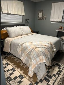 1 dormitorio con 1 cama con manta y alfombra en The Oquirrh Retreat, en Taylorsville