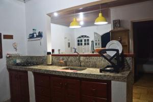 a kitchen with a granite counter top with a sink at Solar dos Ventos BANANEIRAS in Bananeiras