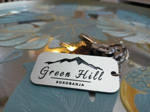 un porte-clés avec les mots « colline verte » inscrits dessus dans l'établissement Opera Lux Apartments Green Hill - Modern Relaxing & Free Parking, à Sokobanja