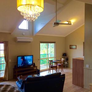 a living room with a couch and a tv and a table at Maleny Luxury Cottages in Maleny