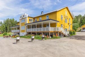 a large yellow building with flowers in front of it at Hotel Merikruunu in Dragsfjärd
