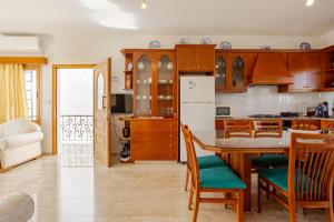 a kitchen with wooden cabinets and a table and chairs at ARMA Resort, 2-bed Cosy Apartment in Tsadha