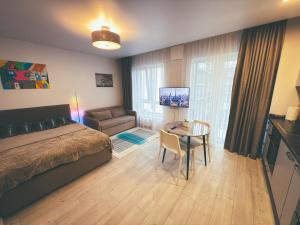 a bedroom with a bed and a table and a couch at Cozy Ozo apartments, free parking! in Vilnius