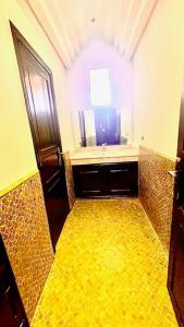 a bathroom with a sink and a yellow tile floor at Villa Rayan Marrakech secteur Palmeraie dans Propriété de 2 hectares avec jardin arbres fruitiers in Marrakesh