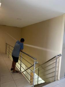 ベレンにあるGaleria Sempre com Deusの部屋の手すりに寄りかかった男