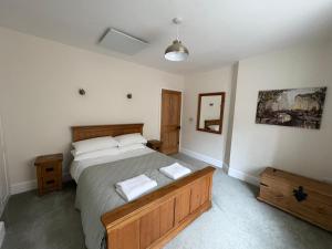 a bedroom with a bed with two towels on it at Willow Cottage in Longney