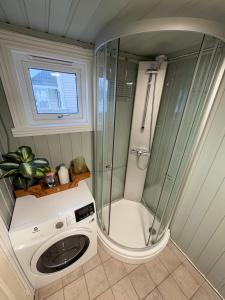 eine Waschmaschine in einem Badezimmer mit Dusche in der Unterkunft Vikanhuset in Andenes + 16 Fotos