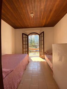 a room with two beds and an open window at Vamos a la playa in Cabo Frio