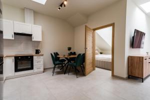 a kitchen and dining room with a table and chairs at Apartament Park Zdrojowy 11 - NOWOŚĆ in Rabka