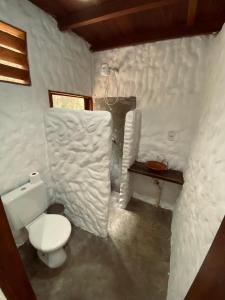 a white bathroom with a toilet and a sink at Casa Muiraquitã Experiências Amazônicas in Santarém