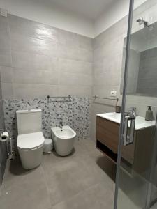 a bathroom with a toilet and a sink at muretti di macchitella in Gela +17 photos