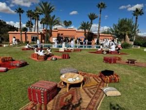 a group of people sitting on the grass in a park at Villa Rayan Marrakech secteur Palmeraie dans Propriété de 2 hectares avec jardin arbres fruitiers in Marrakesh