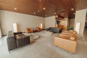 a large living room with leather couches and tables at Hotel Vianorte in Matosinhos