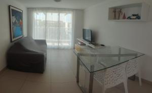 a living room with a glass table and a television at Aquiraz Riviera in Aquiraz