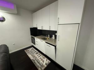 a small kitchen with white cabinets and a refrigerator at Sweet Dreams in Sarajevo +2 photos