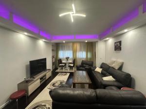 a living room with a couch and a tv at Sweet Dreams in Sarajevo