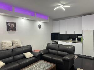 a living room with a couch and a kitchen at Sweet Dreams in Sarajevo