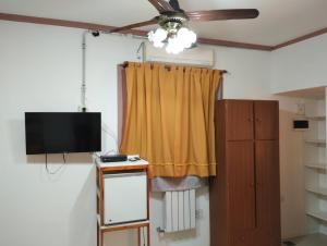 a living room with a ceiling fan and a television at La posada de Norma in Capilla del Monte