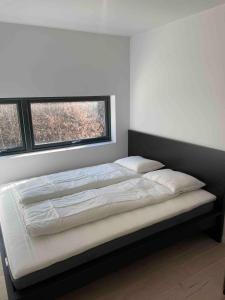 un grande letto in una camera da letto con due finestre di Exclusive apartment in Kristiansand - Høllen a Kristiansand