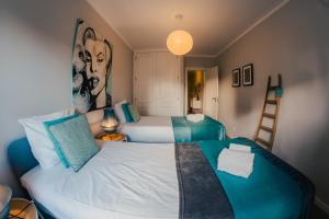 a bedroom with two beds with blue and white pillows at Comfort Zone beach apartment in Quarteira
