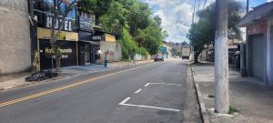 an empty street with a car driving down the street at Hotel Toka do Skillo in Arujá