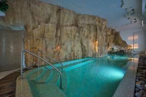 a pool in front of a rock wall at Hotel & Spa Bellavista Francischiello in Massa Lubrense