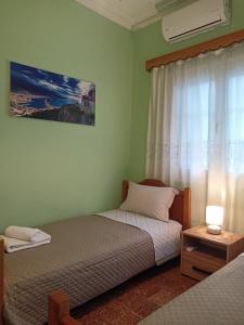 a bedroom with two beds and a window at Kalotina's House in Kalymnos