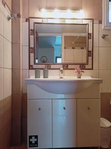 a bathroom with a sink and a mirror at Kalotina's House in Kalymnos