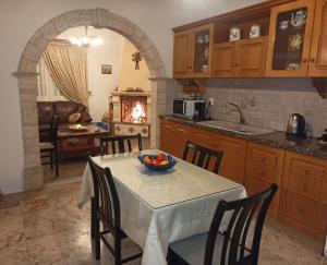 a kitchen with a table with a bowl of fruit on it at Kalotina's House in Kalymnos