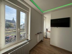 a room with a large window and a flat screen tv at Gîte de la digue in Wimereux