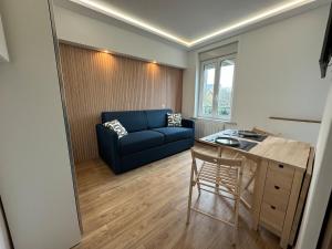 a living room with a blue couch and a table at Gîte de la digue in Wimereux
