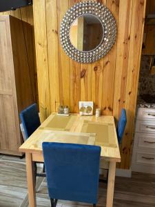 a dining room table with blue chairs and a mirror at La Mia Casa II in Sarasota