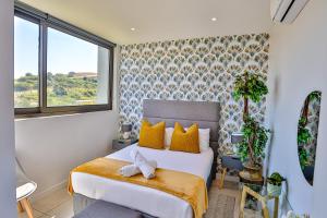 a bedroom with a bed with yellow pillows at Zimbali Lakes Boulevard Suites 103 in Ballito +67 photos