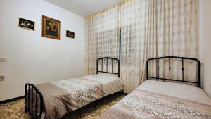 two twin beds in a bedroom with a window at La Casona de Tati in Villanueva de Alcardete +57 photos