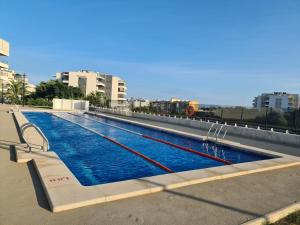 a large swimming pool with blue water in a city at Penthouse Casa SARA, Greenhills, La Zenia, Orihuela Costa in Orihuela +29 photos