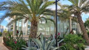 a building with palm trees and plants in front of it at Penthouse Casa SARA, Greenhills, La Zenia, Orihuela Costa in Orihuela